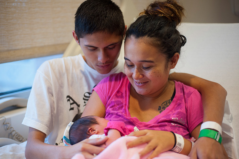 Young parents hold their newborn