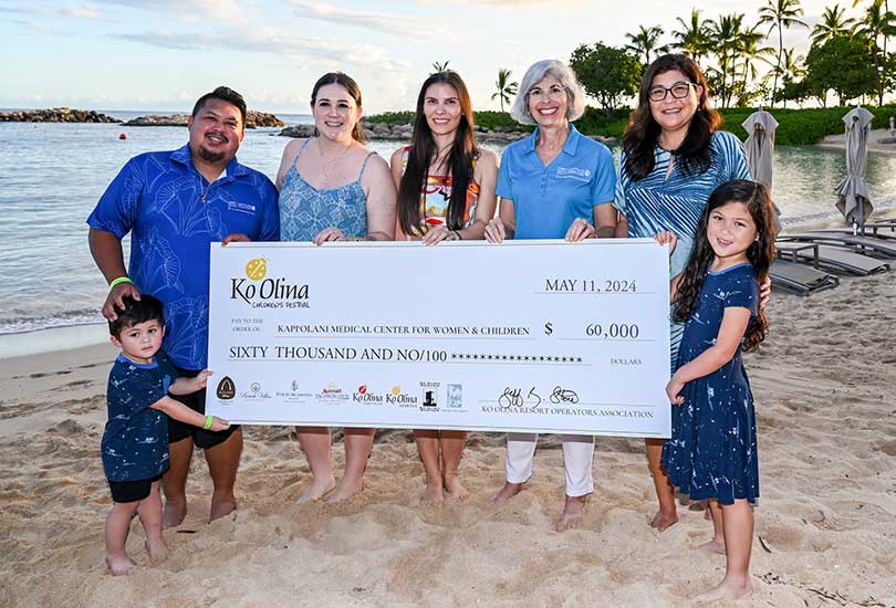 Group holding giant check with $60,000 donation amount.