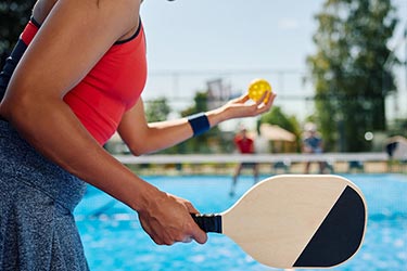 Woman playing pickleball.