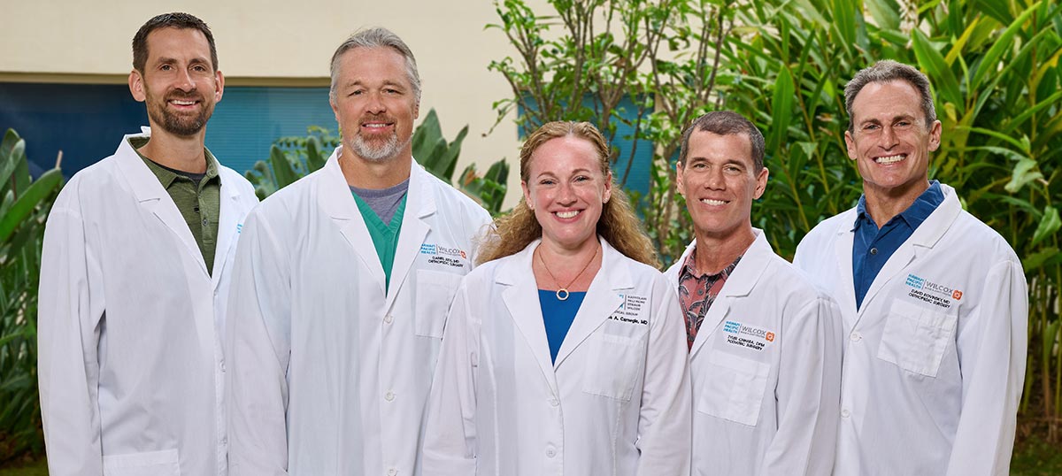 Group shot of physicians in white coats smiling.