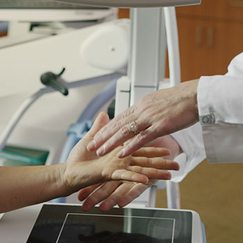 Closeup of orthopedic surgeon examining patient's hand.