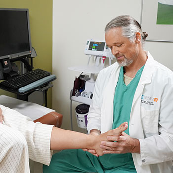 Orthopedic surgeon examining patient's ankle.