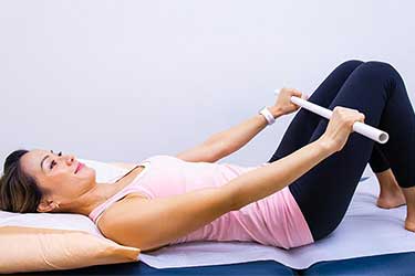 Woman laying on back doing exercise with legs bent.