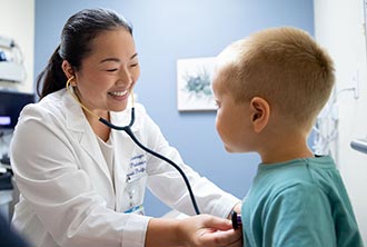 Doctor with a stethoscope examining a young patient.