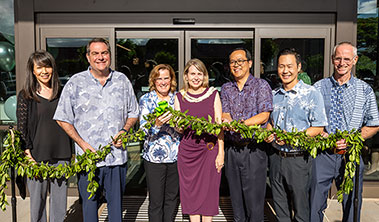 Group shot of healthcare leaders holding maile lei at blessing of Mililani Clinic & Urgent Care.