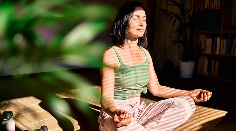 Woman in lotus position with her eyes closed.