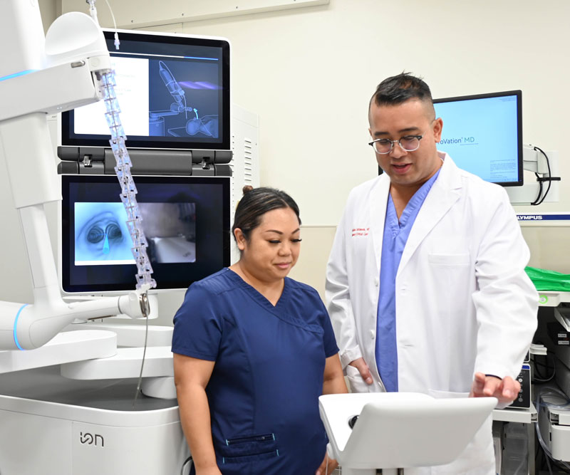 a doctor and nurse look at a monitor in a lung cancer screening room
