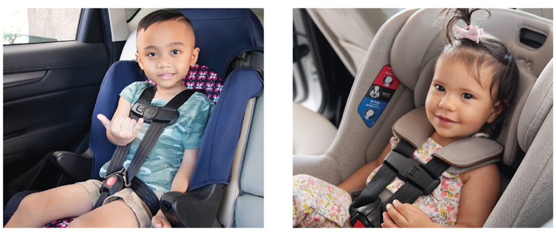 Two children smiling in their car seats.