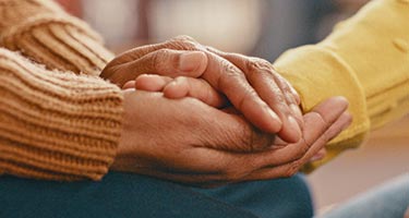 Close up of two people's clasped hands.