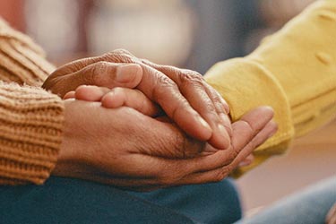 Close up of a hand being held in another's hands.