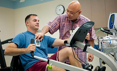 Cardiac patient on an exercise machine having heart readings taken.