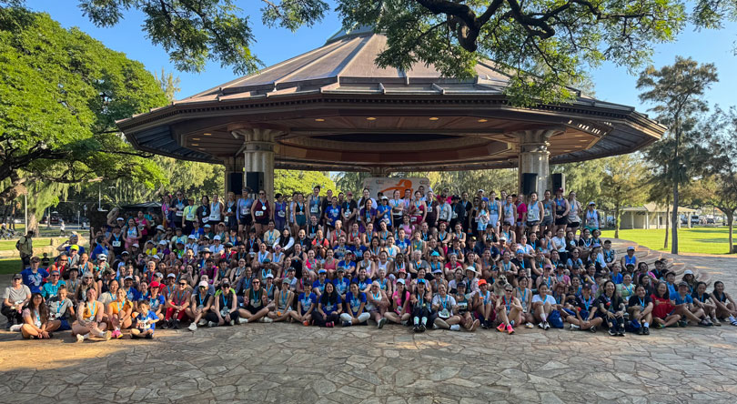 Large group of female race participants gathered at the Kapiolani Park Bandstand.
