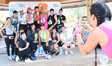 group of women holding up medals while another woman takes photo with a phone