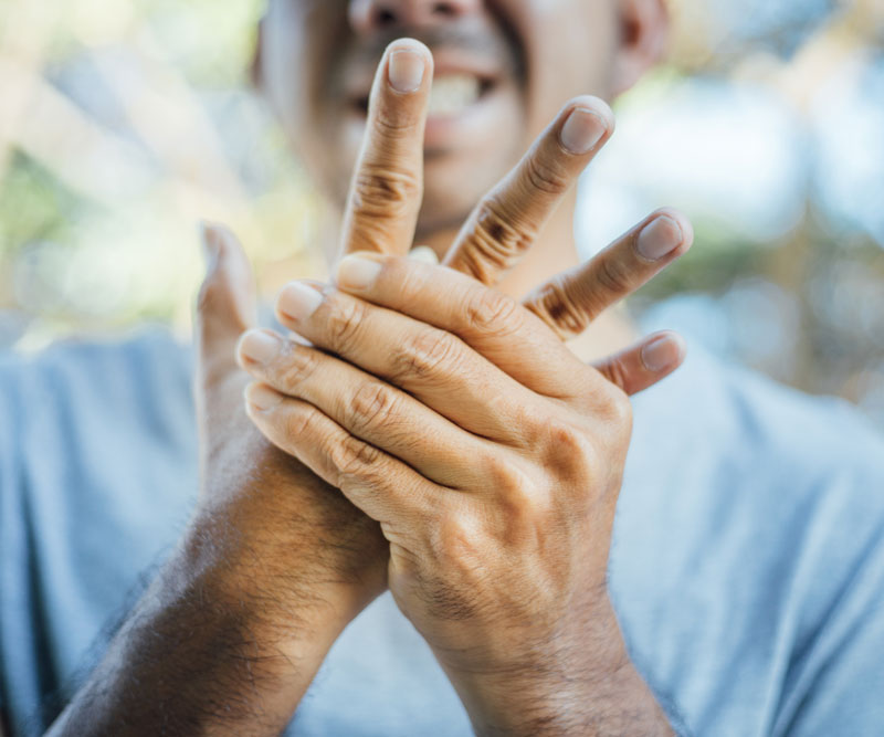 man holds hand in pain