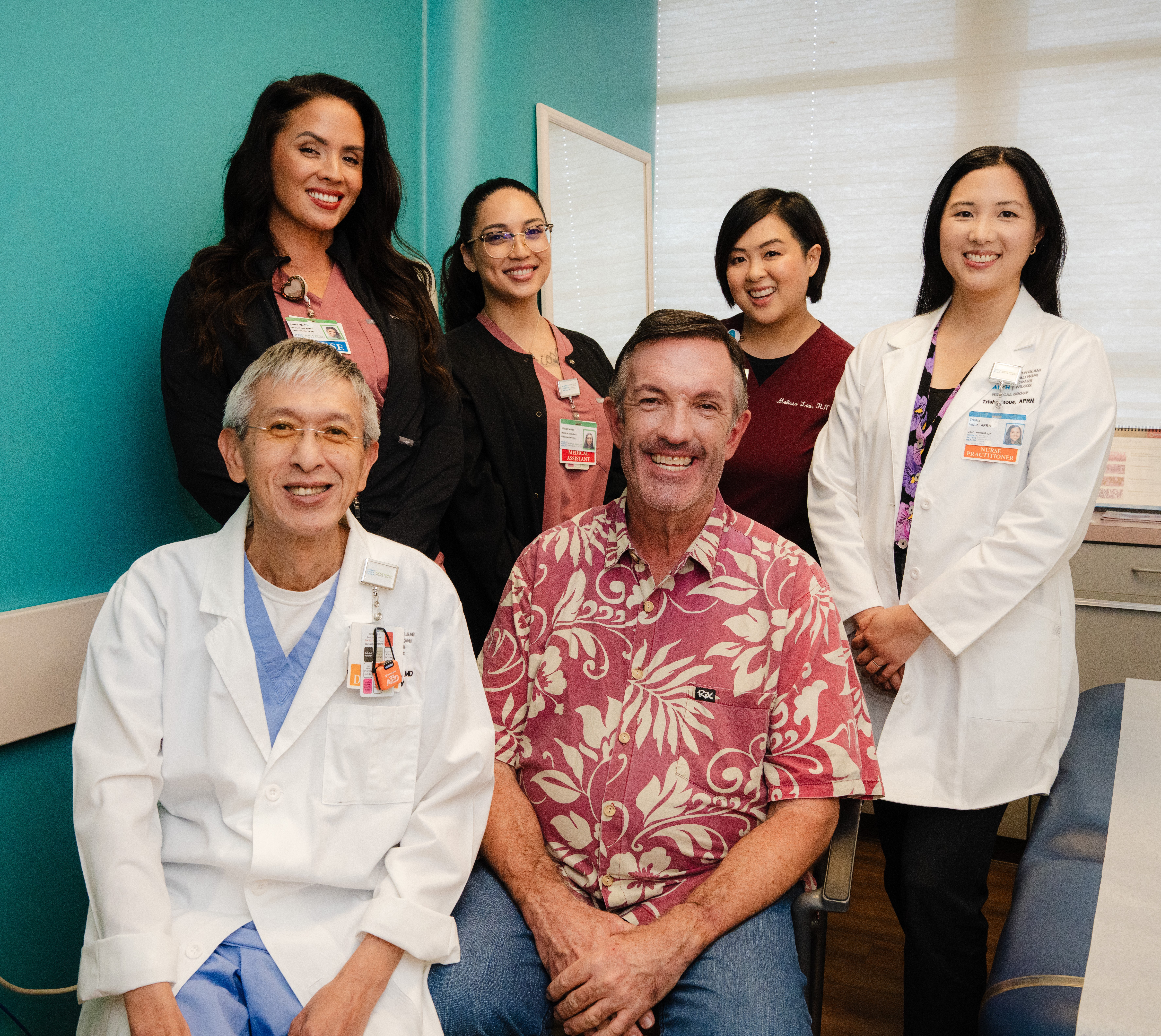Patient and staff group shot in medical examination room.