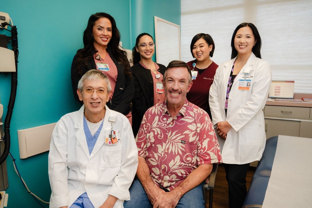 Patient and staff group shot in medical examination room.