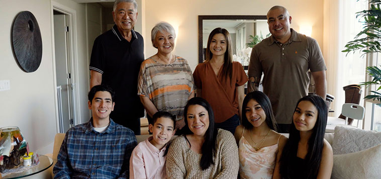 Group shot of a patient surrounded by her large family at home.