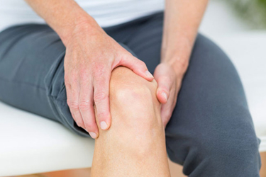 Man rubbing his sore knee