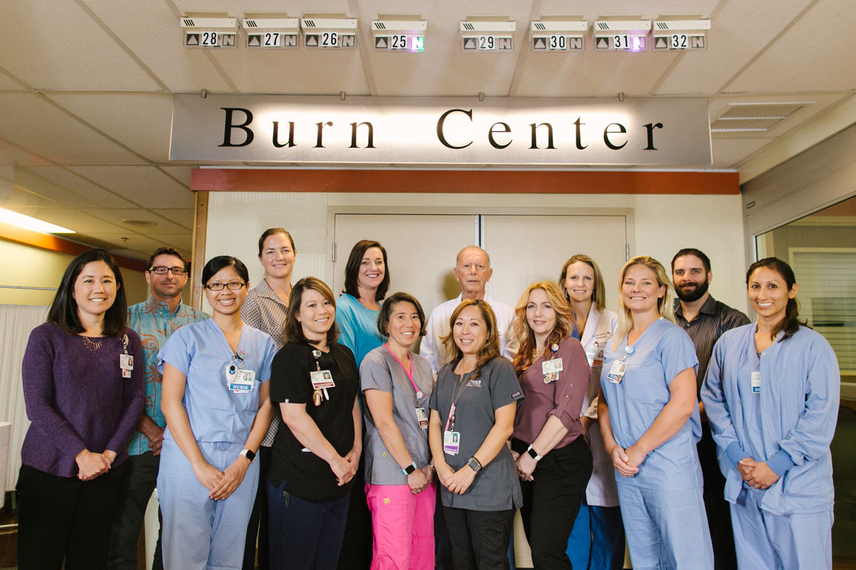 physicians and staff of the Straub Benioff Burn Care Unit stand in front of the office doors and sign