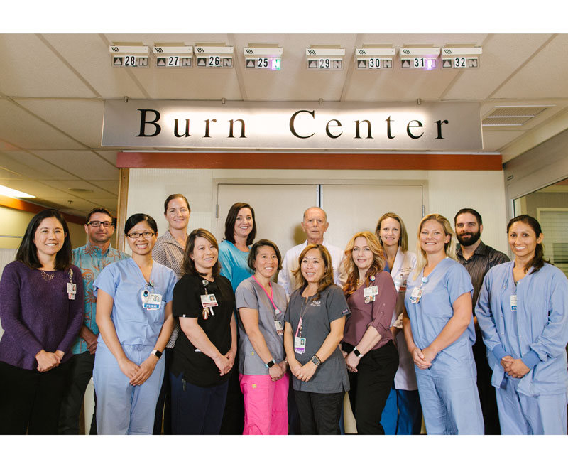physicians and staff of the Straub Benioff Burn Care Unit stand in front of the office doors and sign